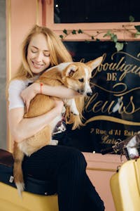 Happy dog with owner and vet bills in background
