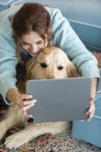 Pet parent comparing pet insurance quotes on laptop with happy dog beside – 2025